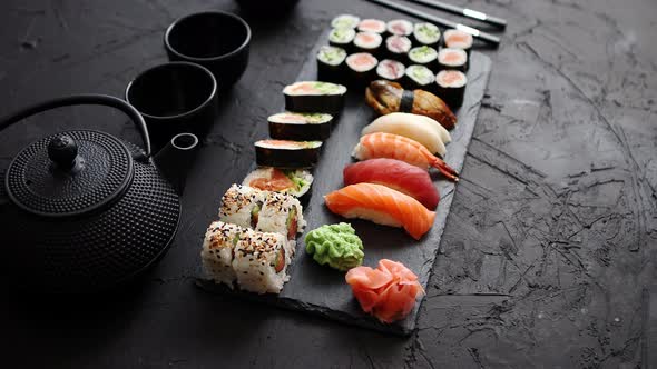 Assortment of Different Kinds of Sushi Rolls Placed on Black Stone Board