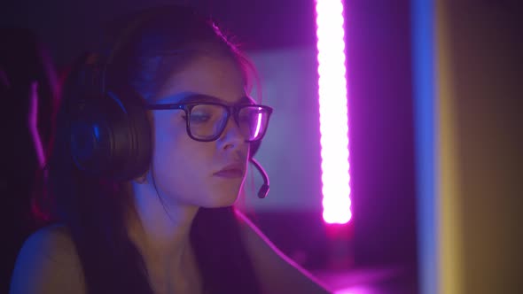 Young Pretty Woman in Glasses Playing Games in Neon Gaming Club