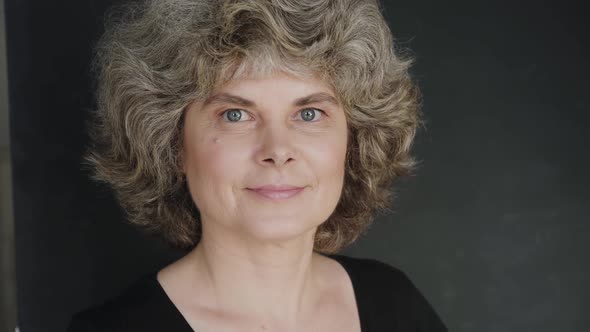 Portrait of Happy Woman Looking and Smiling at Camera on Background