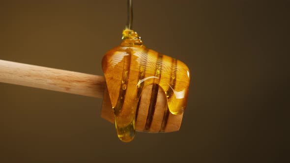 Sweet Honey Flowing on Wooden Spoonspindle Closeup