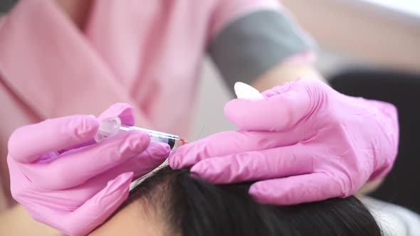 Handsome woman receives an injection in the head. The concept of mesotherapy.