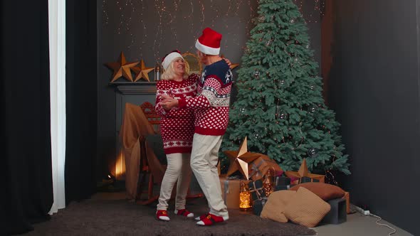 Cheerful Smiling Married Senior Couple Grandparents in Decorated Room Celebrating Christmas Together