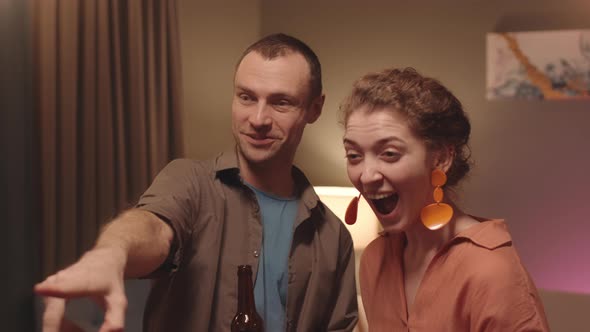 Cheerful Couple with Drinks at House Party