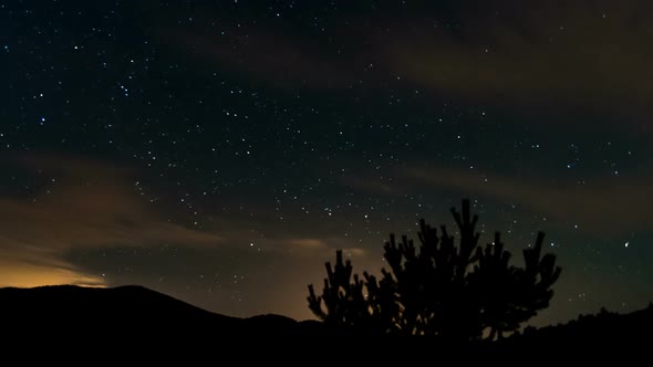 Fast Clouds in Starry Sky with Stars in Dark Night over Forest Mountains Nature Landscape