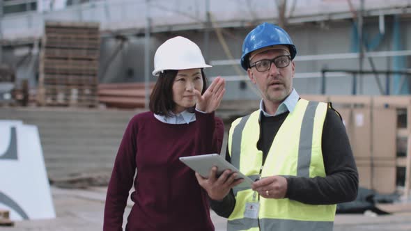 Construction workers discussing project development on site