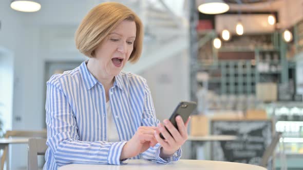 Success on Smartphone By Creative Old Woman in Cafe 