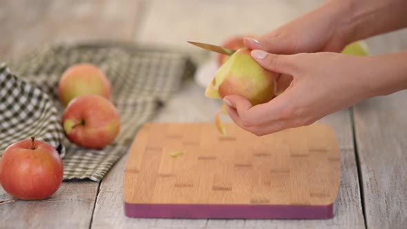 Young Woman Peeling Apple in Kitchen