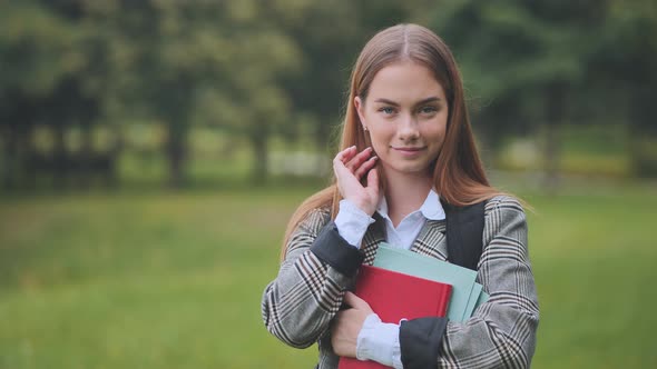 A Smiling Student with Books in the Park