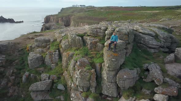 Man on top of a cliff in Cornwall enjoying the view