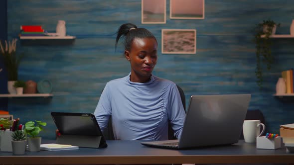 African Woman Using Laptop and Tablet in Same Time Overwork