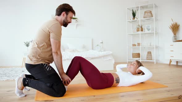 Young Couple is Doing Sport Excercises at Home in Cozy Bright Bedroom