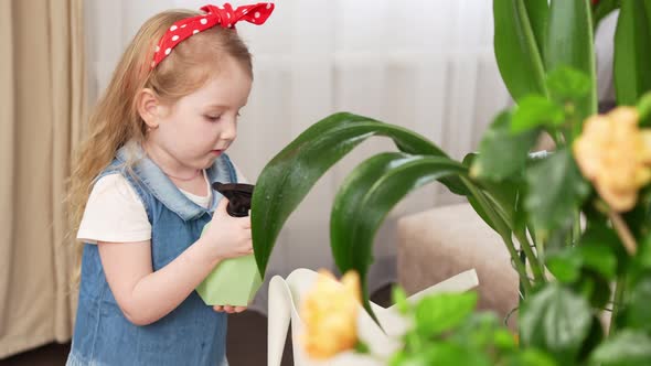 a Little Pretty Girl Sprays the Houseplant with Water