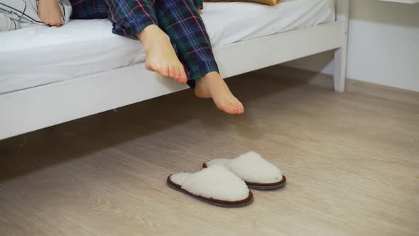 Woman Putting on Slippers in the Morning