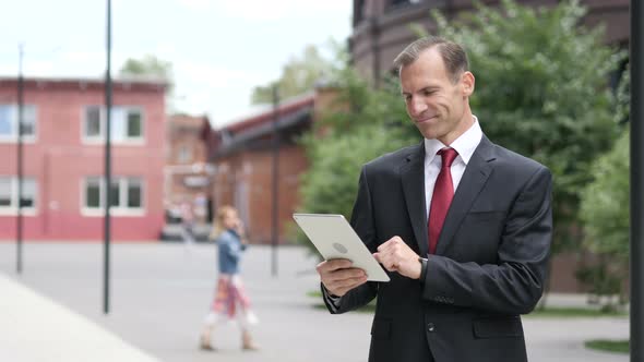 Businessman Browsing Internet on Tablet