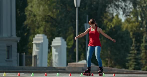 Young Woman Goes Round the Cones on Roller Skates Slalom Element Criss Cross