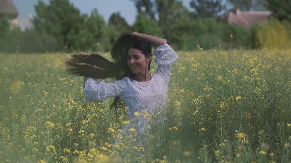 Pretty young woman in the rapeseed field