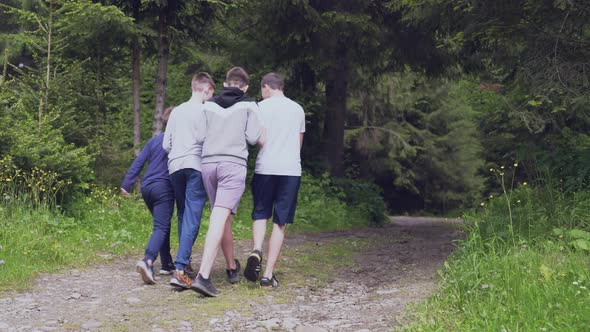 Teens Walking Through Wet Spruce Forest Road.