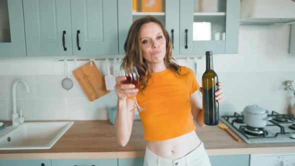 A Beautiful Woman in White Shorts is Relaxing at Home Dancing in the Kitchen