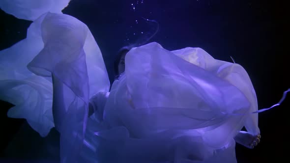 Folds of White Transparent Fabric Move Beautifully in the Dark Water. the Head of a Girl with Long