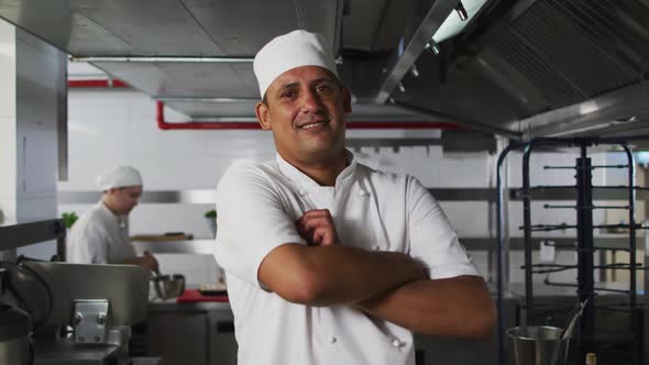 Portrait of mixed race male chef with arms crossed looking at camera