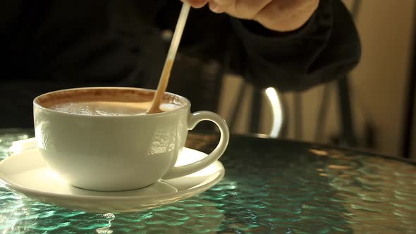 Stirring cappuccino at a showing concept of the cozy warmth of the Autumn and Winter Season