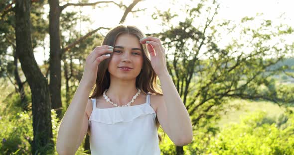 Attractive Smiling European Teen Girl with Enjoys Moment and Looks Into the Camera in Nature on a