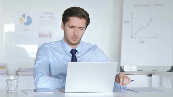 Stressed Young Businessman Sitting Upset at Work