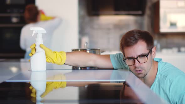 Happy Couple Doing House Cleaning in Modern Kitchen at Home