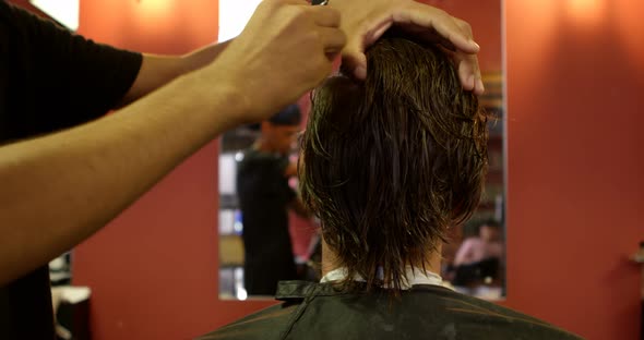 Barber combing mans hair 
