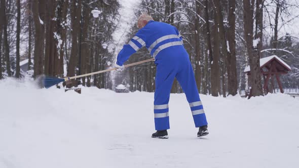 Senior Cleaner Removing Snow.