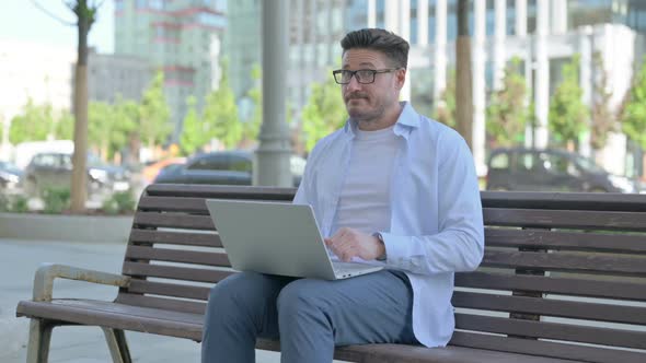 Rejecting Man in Denial While Using Laptop Sitting Outdoor on Bench