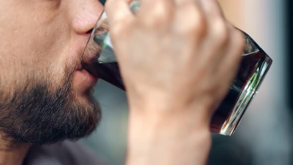 Extreme Closeup Male Mouth with Beard and Mustache Drinking Refreshing Craft Beer From Glass Mug