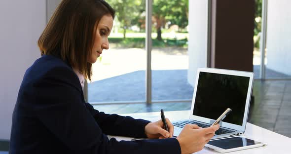 Businesswoman working on laptop at desk 