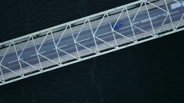 Bird's Eye View of a Bridge Spanning a Fast Flowing Dark River