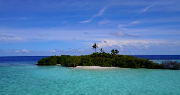 Wide fly over copy space shot of a white sandy paradise beach and blue ocean background