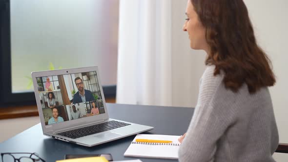 Young Woman Using a Laptop for Video Connection with Diverse Group of People