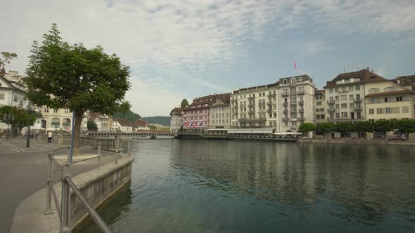 Establishing shot of Lucerne Old Town picturesque buildings next to Reuss River at daytime, Switzerl