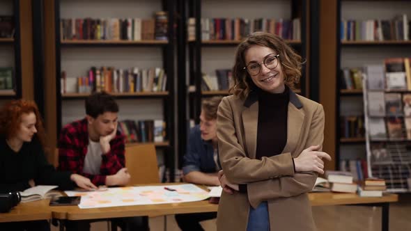 Portrait of an Attractive Short Haired European Girl Student in Glasses and Brown Jacket Standing in