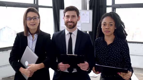 Multiracial Influential Business People in Formal Wear Look at the Camera Smiling