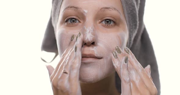 Portrait of a Young Beautiful Woman with Towel on Her Head Washing Her Face with a Nature Cleanser