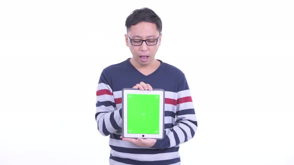 Stressed Japanese Hipster Man Showing Digital Tablet and Getting Bad News