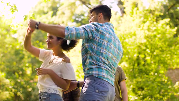 Happy Friends Dancing at Summer Party in Park 