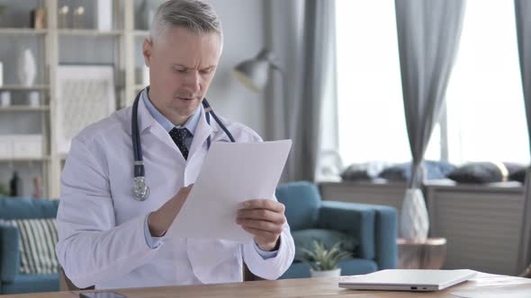 Doctor Reading Medical Report of Patient