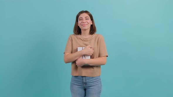 Joyful Woman Embracing Wrapped Gift Box and Smiling with Excitement