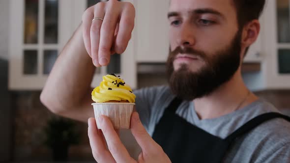 A Pastry Chef in the Kitchen Decorating a Cupcake with Chocolate Chips