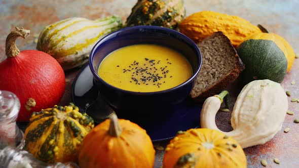 Compositon with Autumn Classic Food. Tasty Homemade Pumpkin Soup Decorated with Black Seed