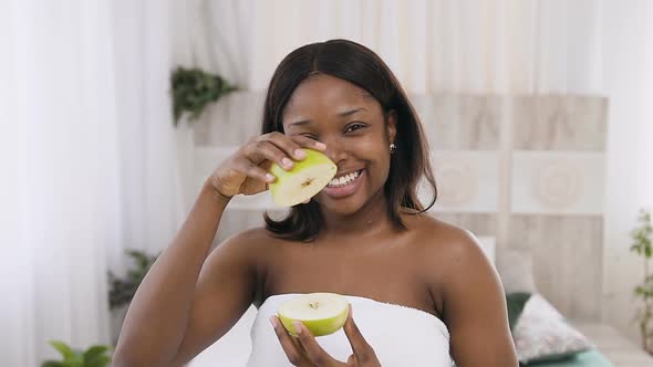 African American Woman Holding Apples Slices in Hands While Posing Smiling on the Camera