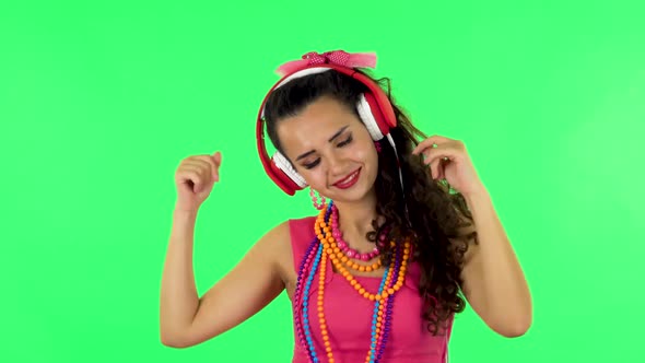 Girl Dancing and Singing in Big Red Headphones on Green Screen