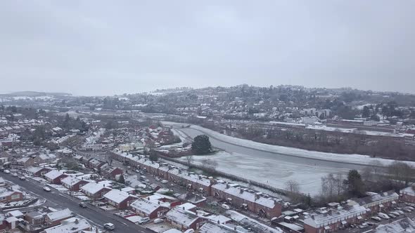 Track forward panning drone shot of snowy Exeter over the River Exe