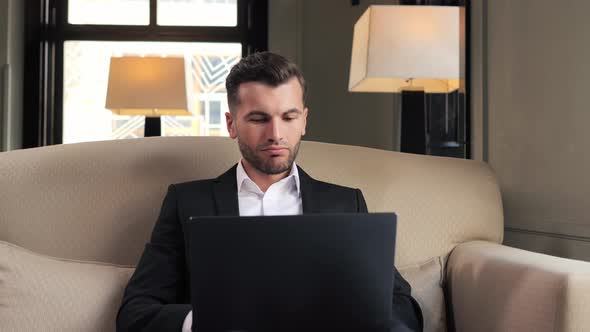Portrait of Male Manager Looking on Laptop Screen at Remote Workplace